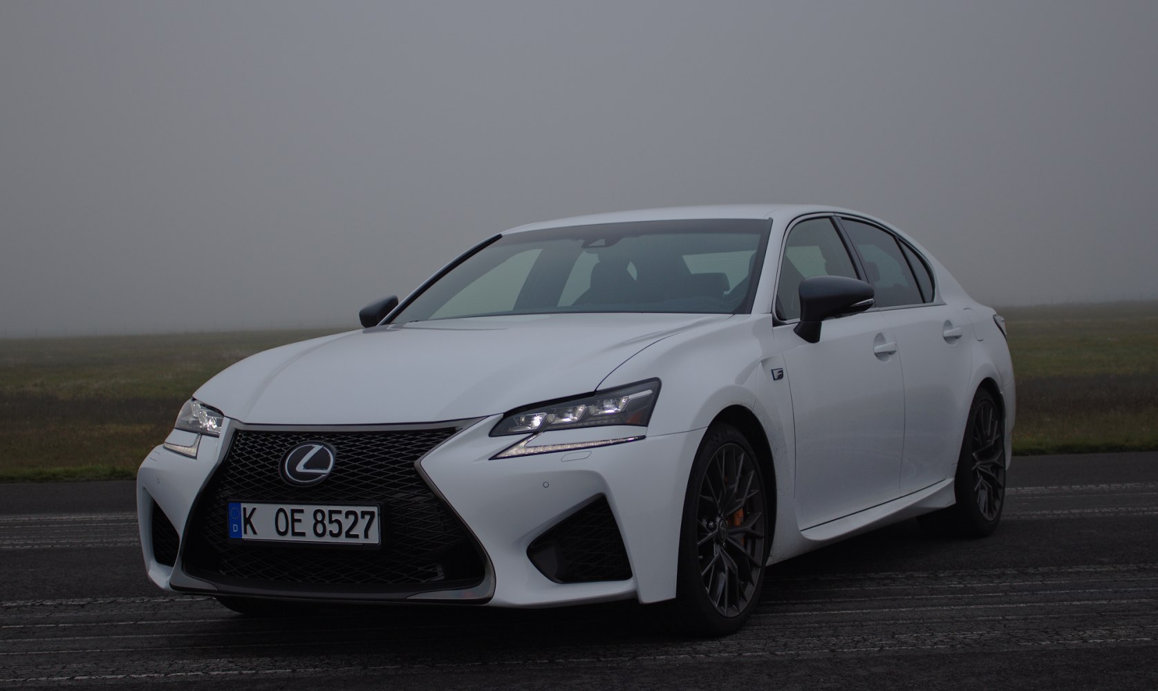Front angled view with LED headlights and spindle grille on white luxury sedan