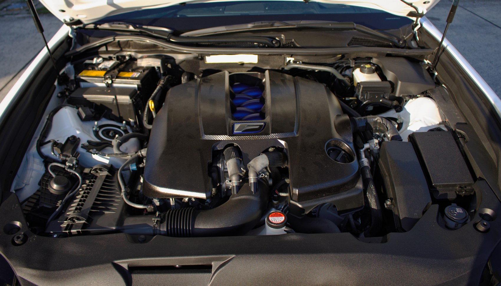 Close-up of modern luxury sedan engine bay with distinctive central cover and visible components