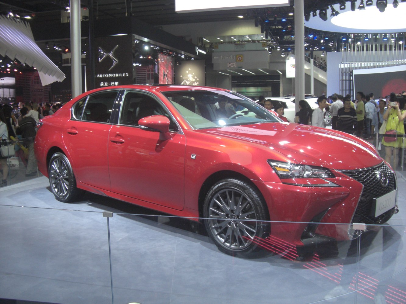Red luxury sedan with aggressive front grille and alloy wheels