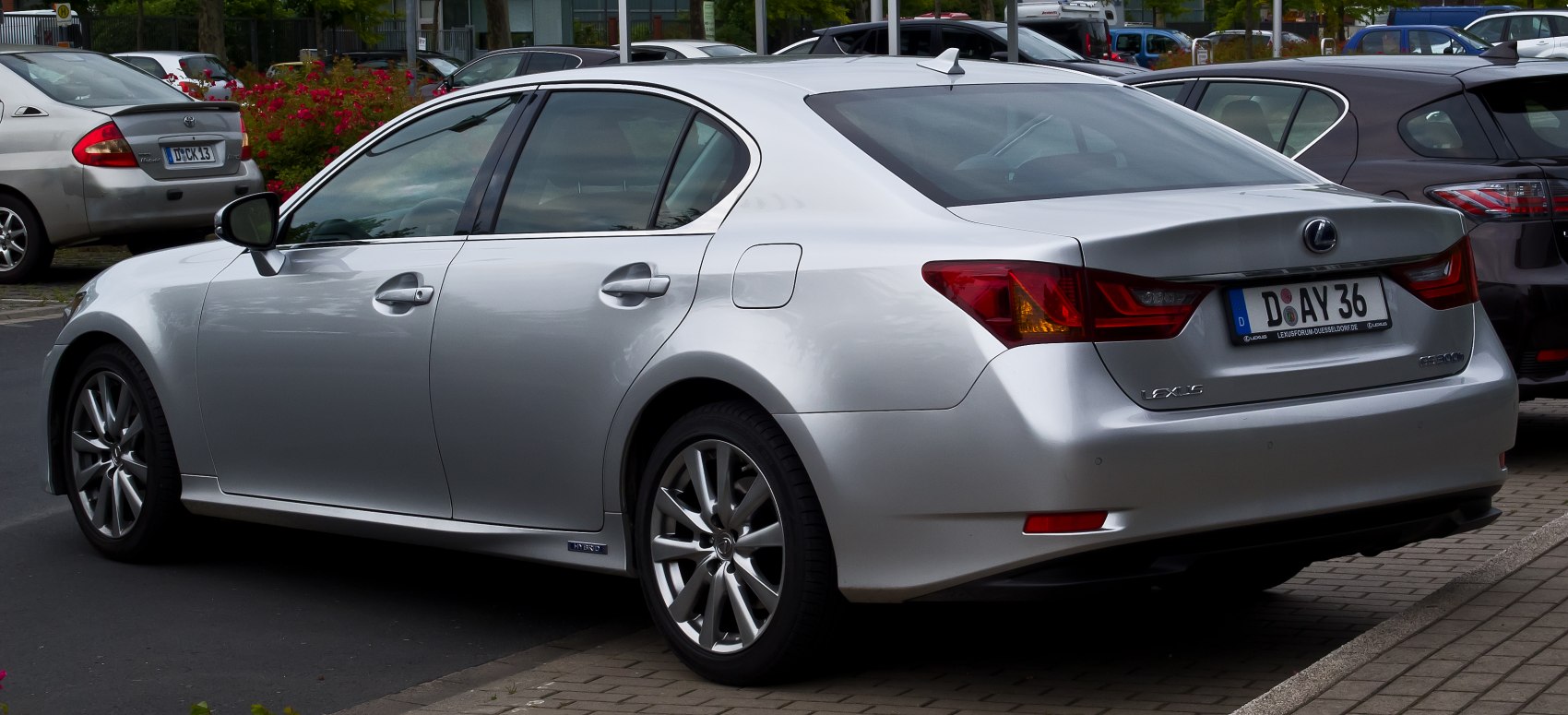 Rear side view of silver hybrid sedan with distinctive tail lights and shark fin antenna