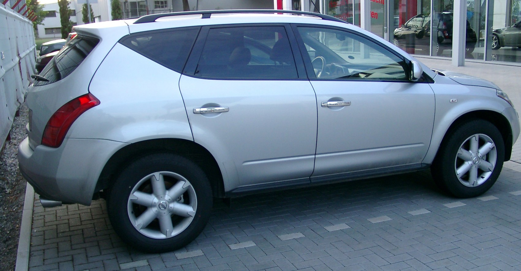 Silver SUV side view with alloy wheels and unique rear window design