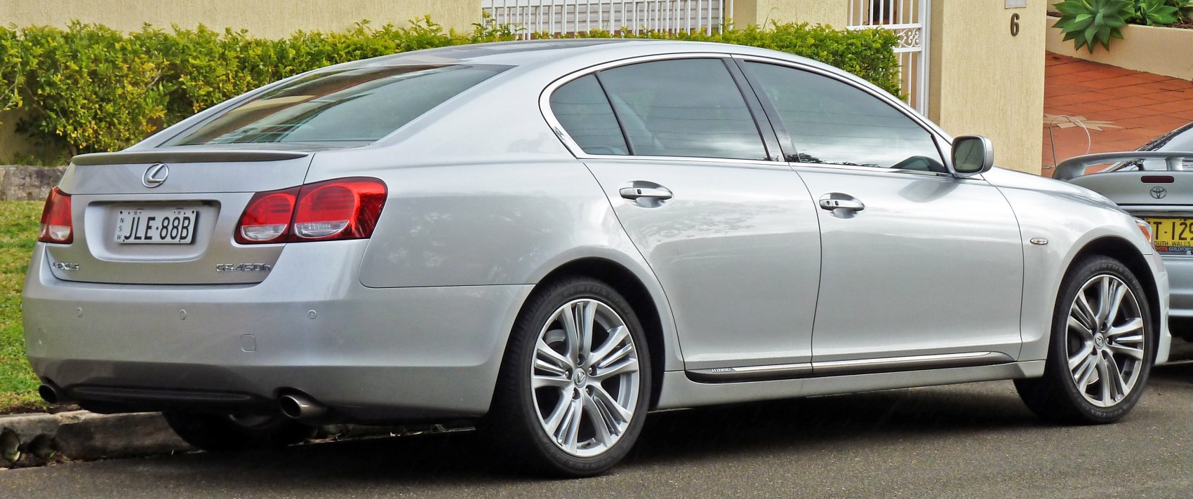 Silver luxury sedan showing rear side with taillights and alloy wheels