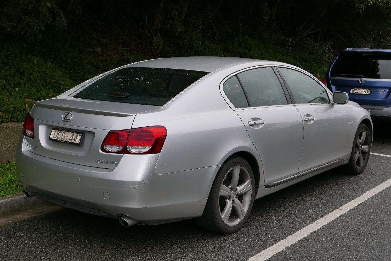 Rear view of silver sedan with distinct tail lights and dual exhaust.