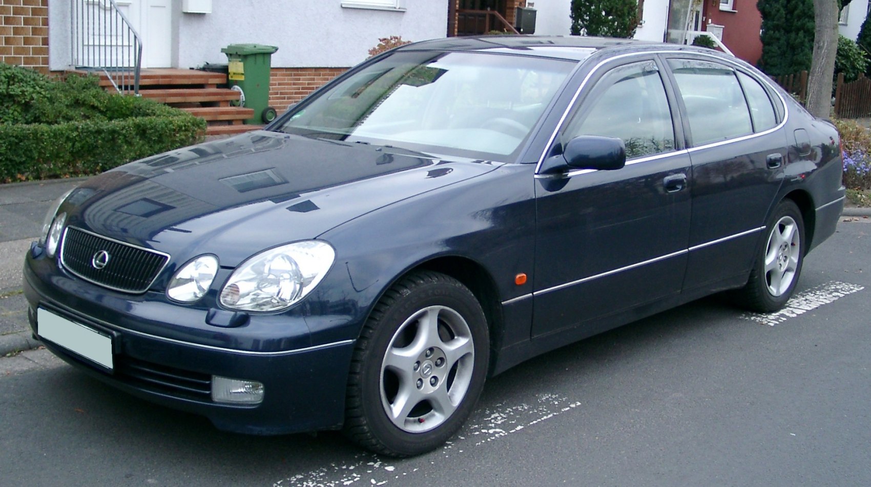 Front three-quarter view of a sleek four-door sedan with distinctive headlights and smooth design.