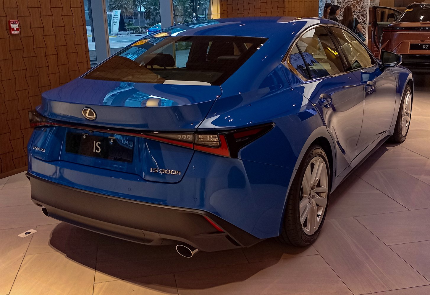 Rear and side view of blue sedan with sharp tail lights and sloping roofline
