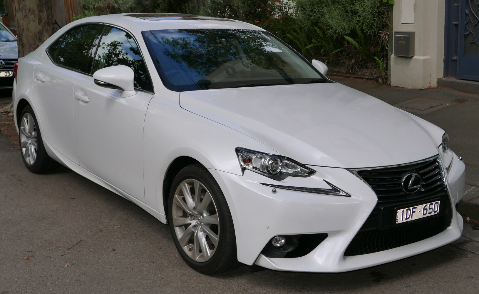 White sedan front side with spindle grille and sharp headlights
