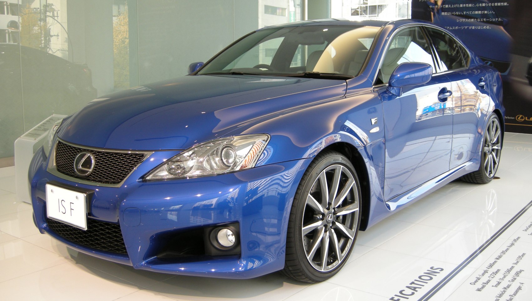 Close-up of front headlight and sporty alloy wheel