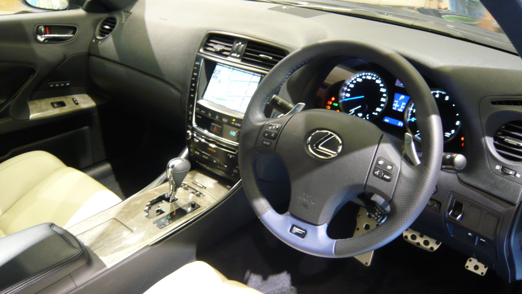 Lexus steering wheel with logo, digital instrument cluster, center console with gear shift