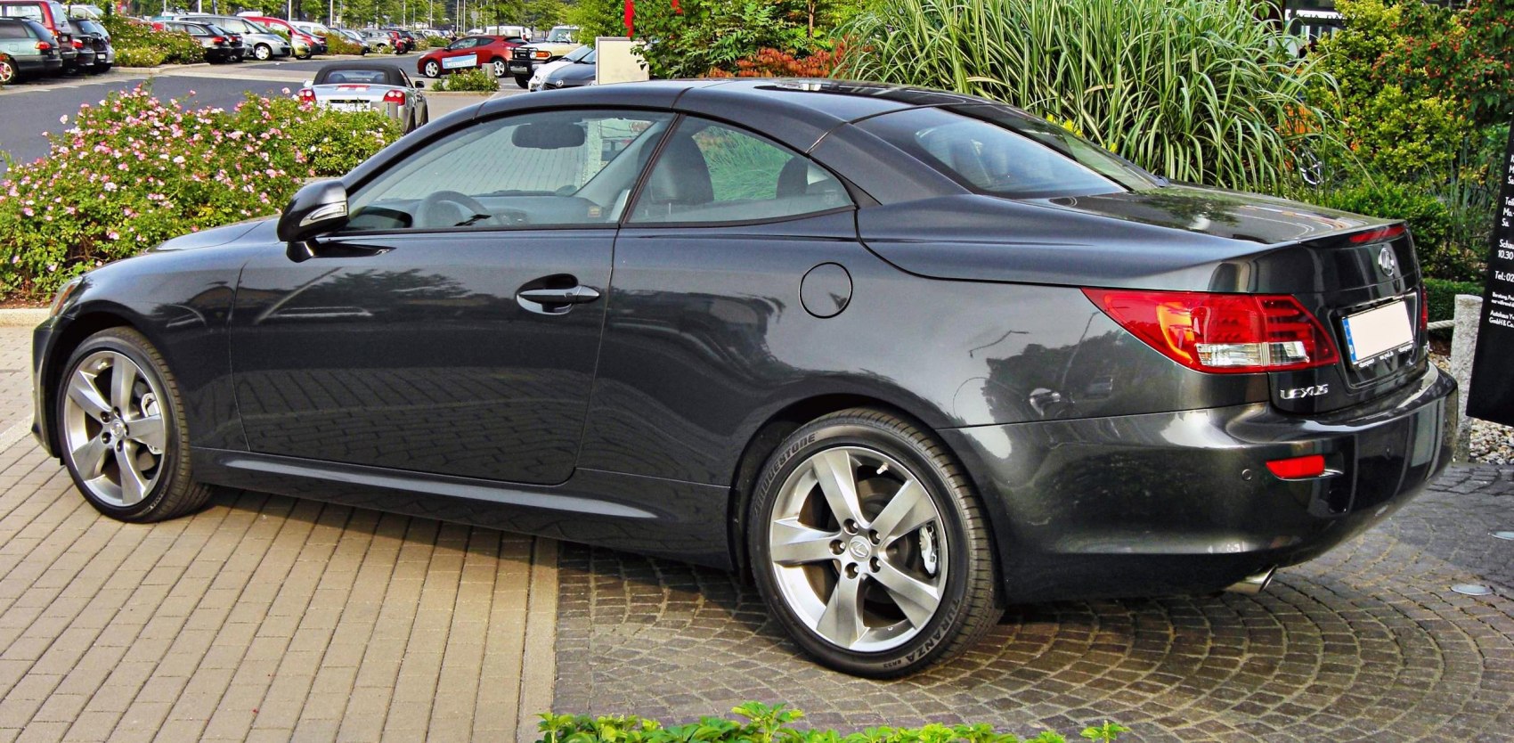 Rear-side view of a sleek convertible with hardtop roof and alloy wheels
