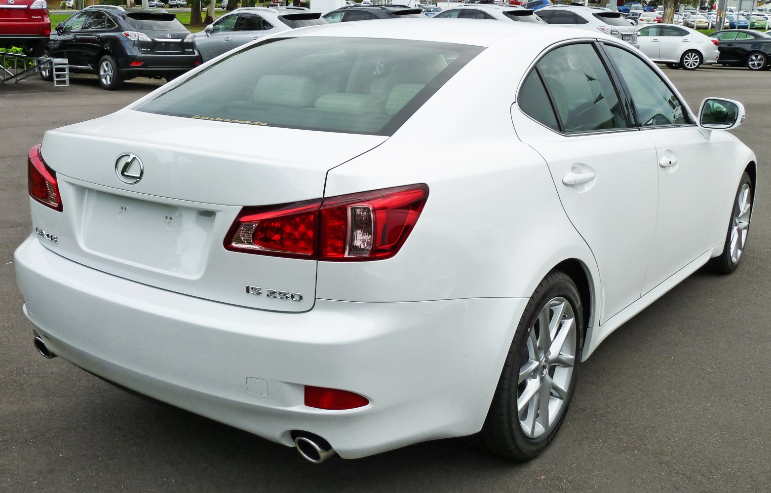 Rear view of a white sedan with distinctive tail lights and dual exhaust pipes
