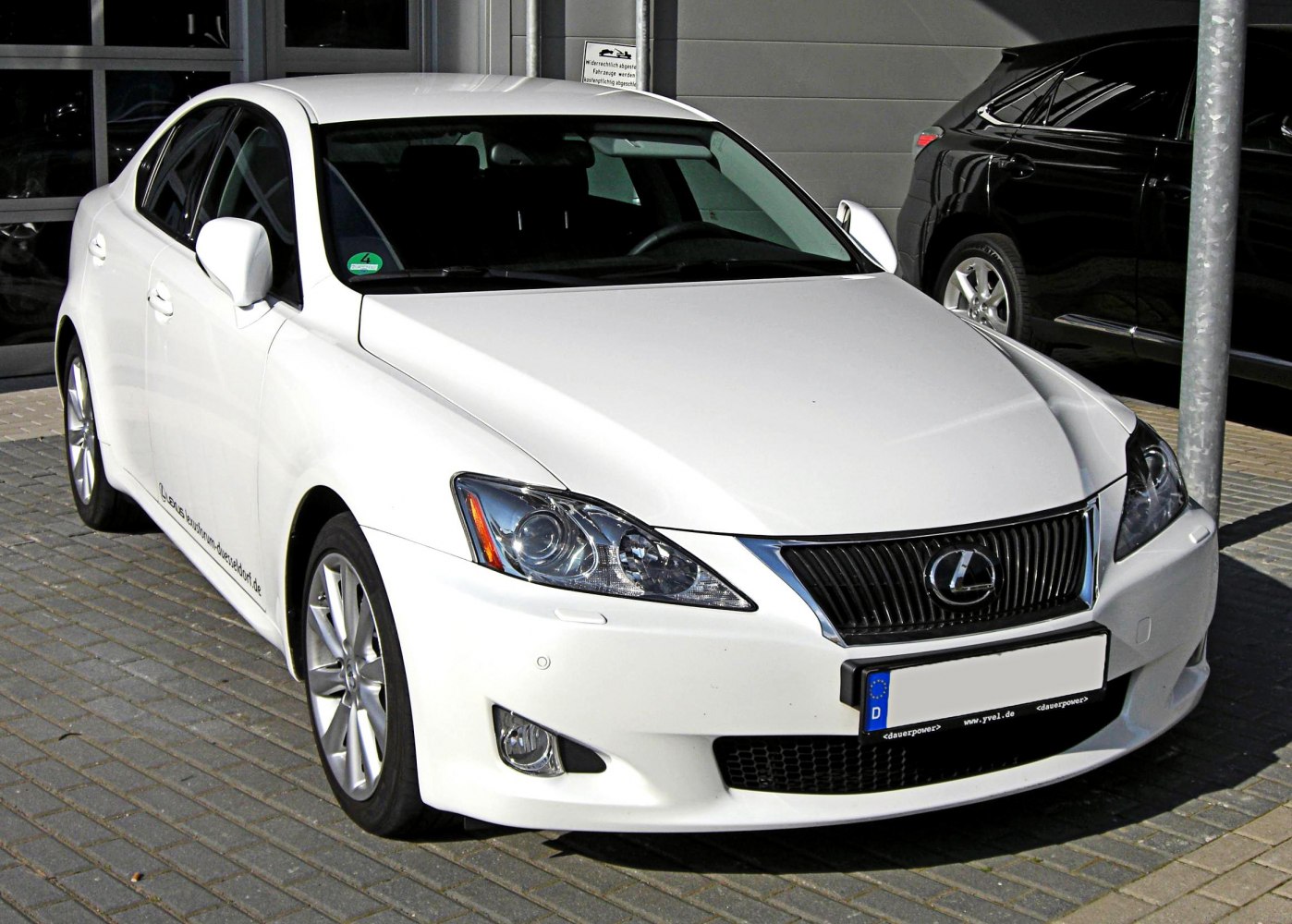 Front view of white sedan with prominent headlights and grille