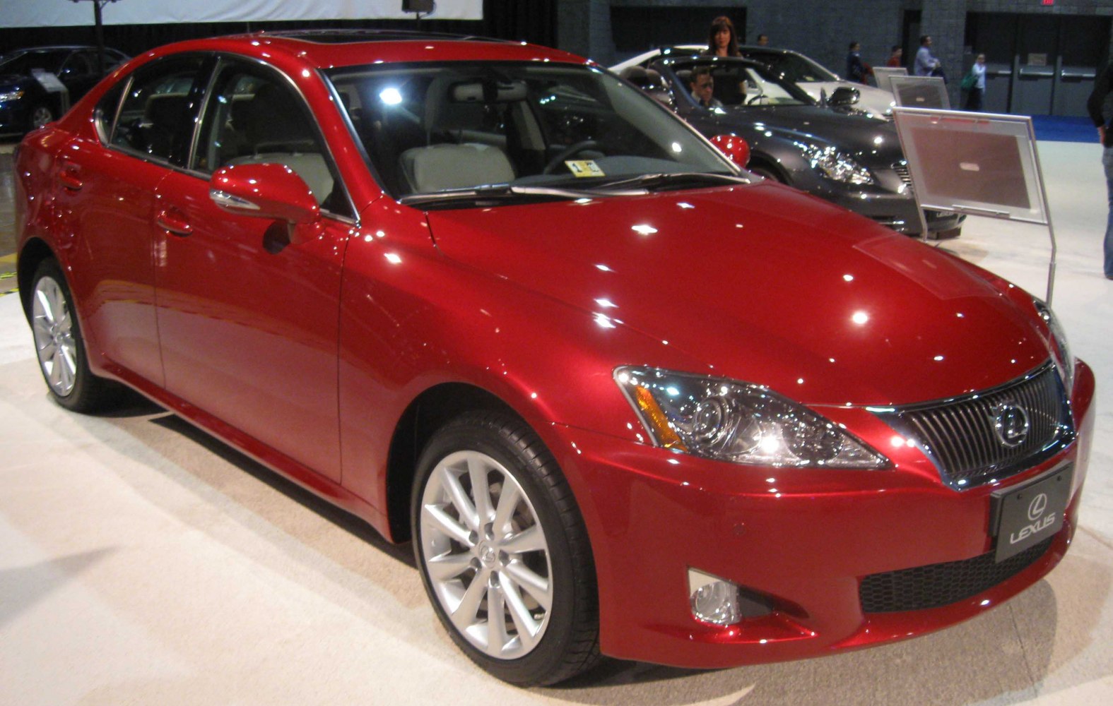 Red Lexus sedan with sleek headlights and alloy wheels