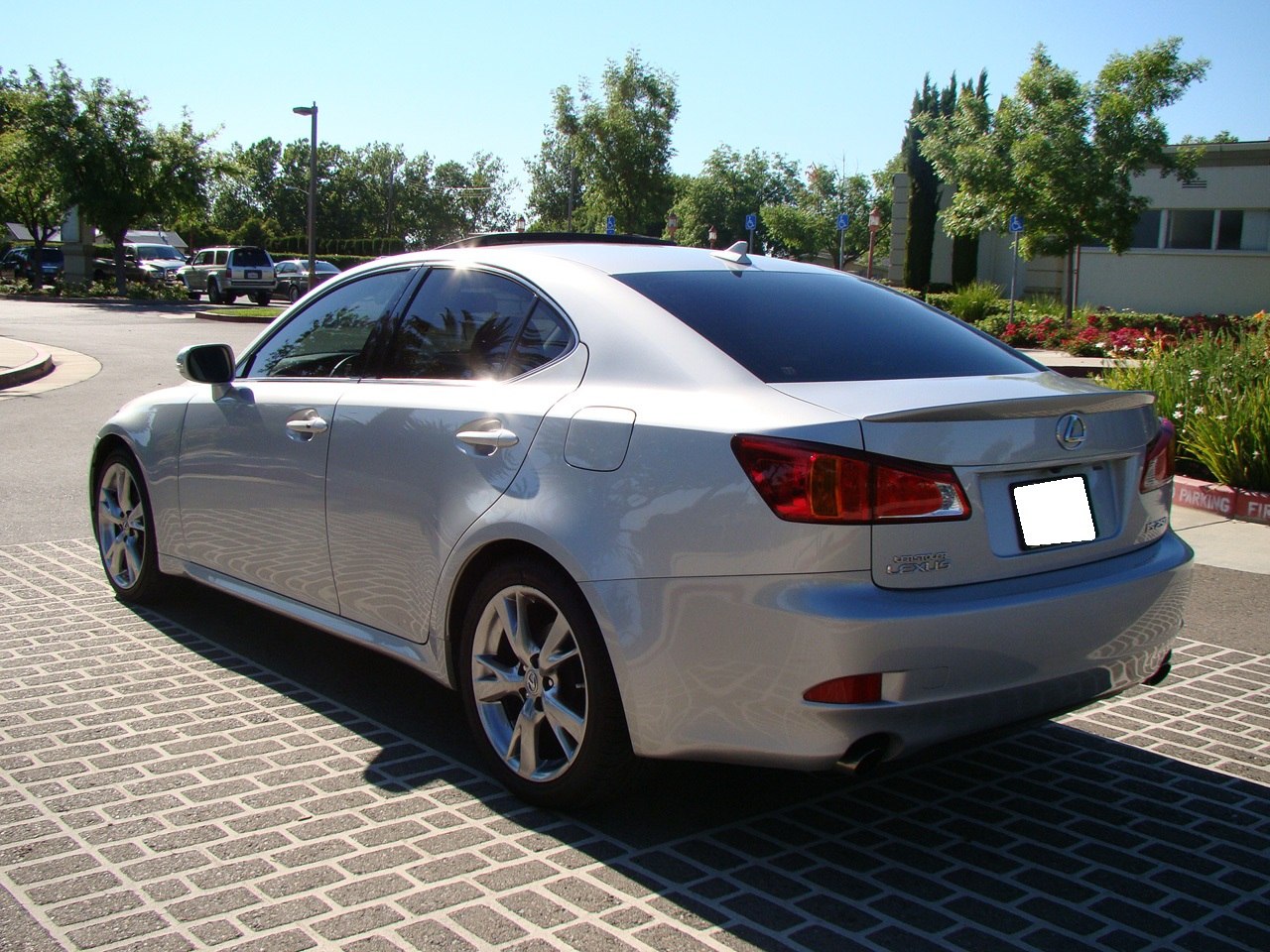 Rear and side view of silver sedan with alloy wheels and tinted windows