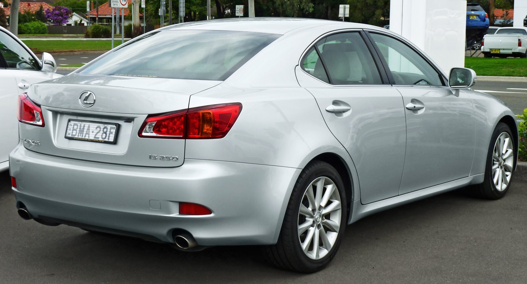 Rear and side view of silver luxury sedan with distinctive tail lights and dual exhaust