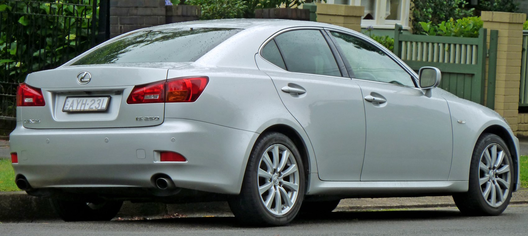 Rear side view of silver sedan with alloy wheels and dual exhaust pipes