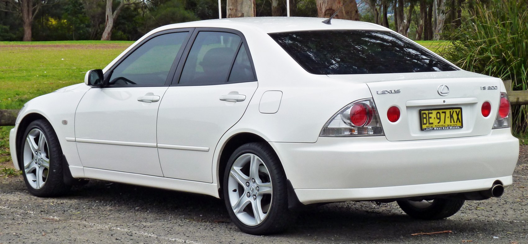 White sedan with circular taillights and alloy wheels
