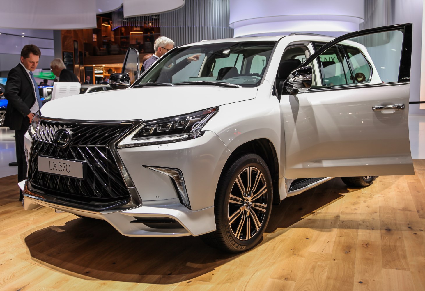 Front grille and LED headlights of a luxury SUV with open door
