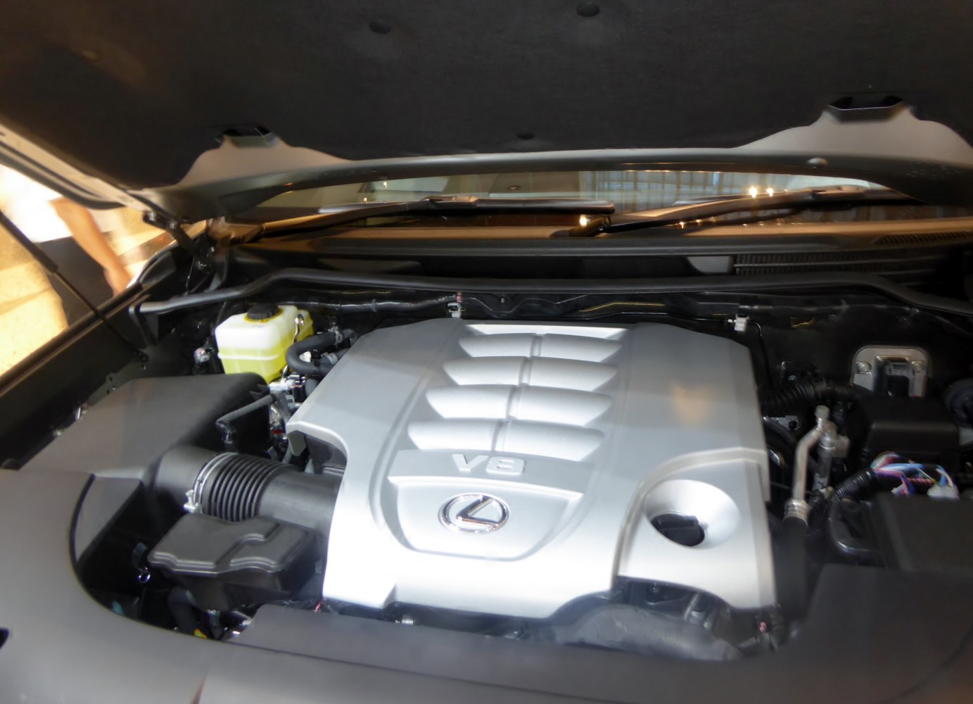 Engine bay with silver V8 engine cover and visible surrounding components