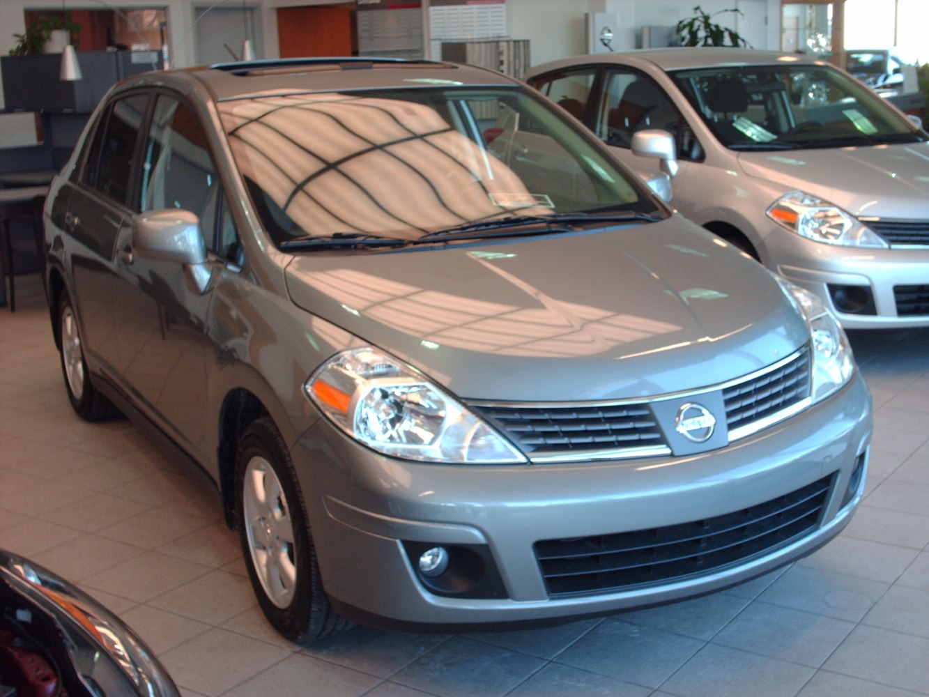 Front three-quarter view of a compact sedan in showroom.