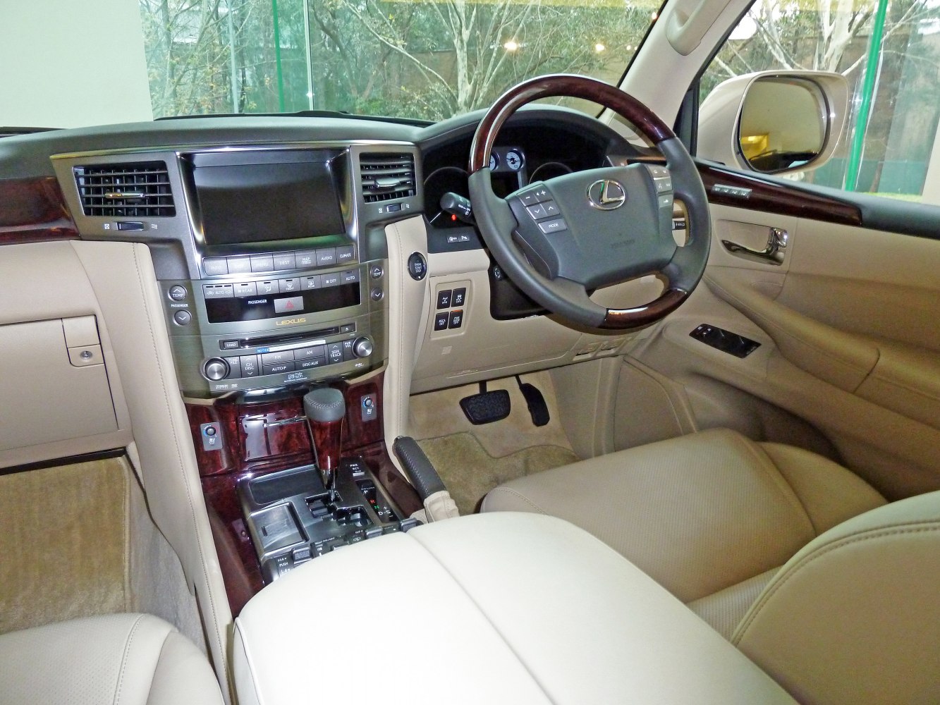 Luxury vehicle interior with dashboard, steering wheel, and wood trim