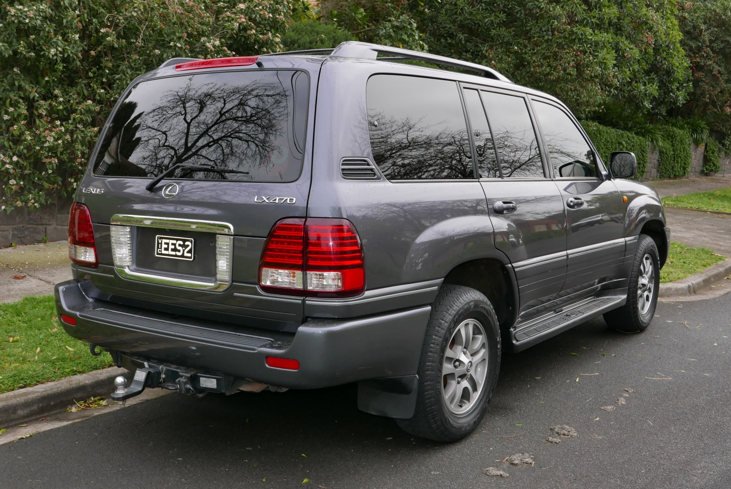 Rear side view of SUV with tinted windows and roof rails