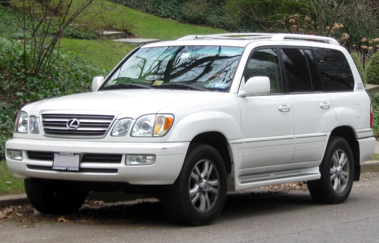 Front side view of a white luxury SUV with distinctive grille and headlights