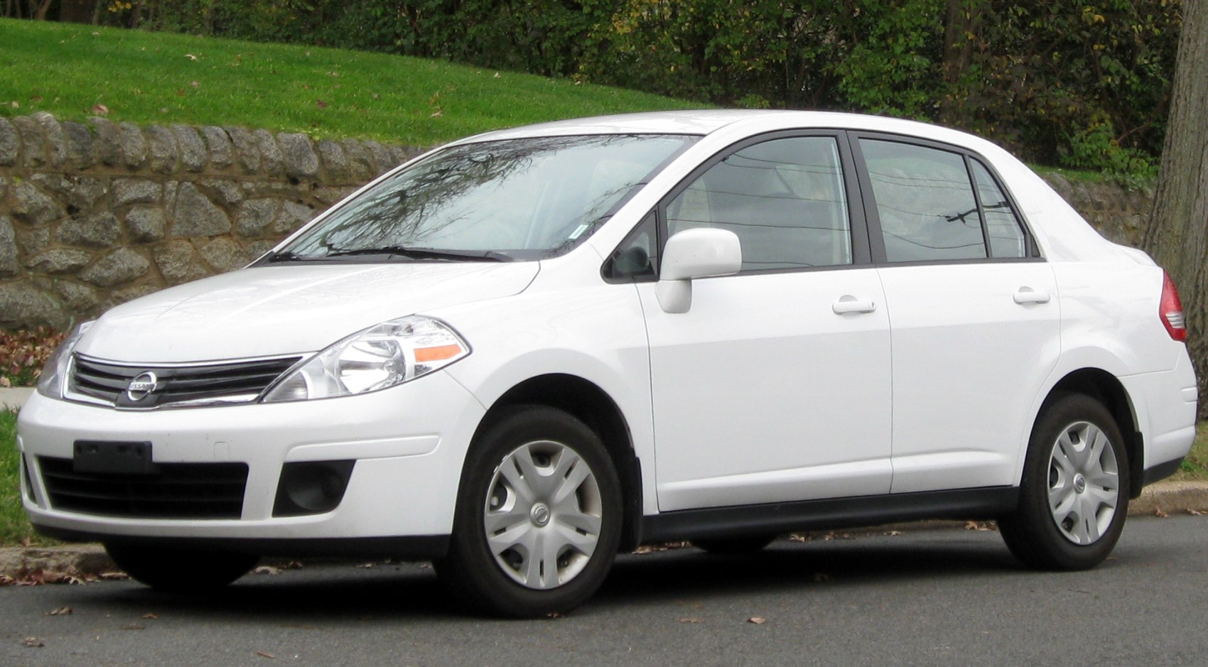 Compact sedan front side profile with distinctive headlights and grille