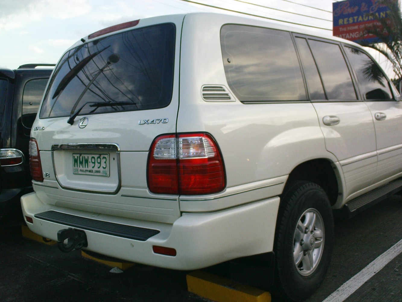 Rear and side view of luxury SUV with tow hitch and tinted windows.