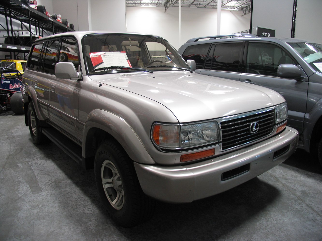 Front side view of a metallic silver SUV with chrome grille and vintage 90's styling