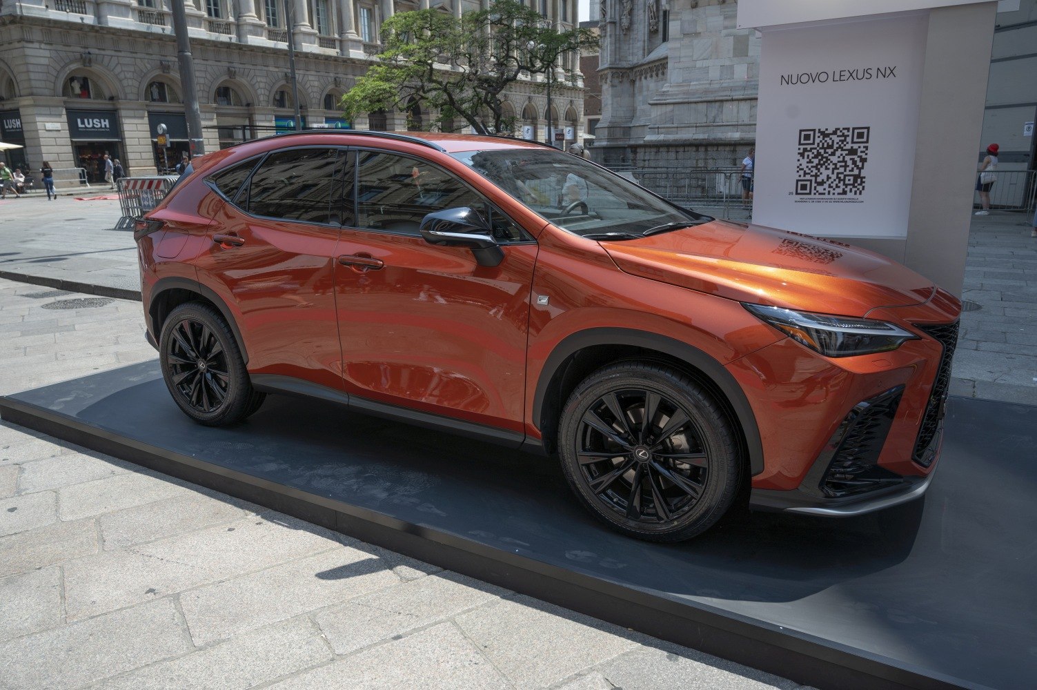 Side profile of a sleek orange SUV with black wheels and sporty design