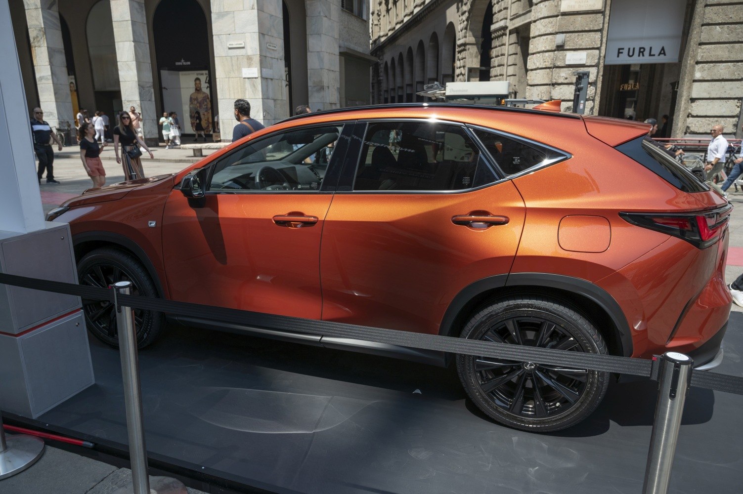 Side profile of orange SUV with black wheels and sporty rear design