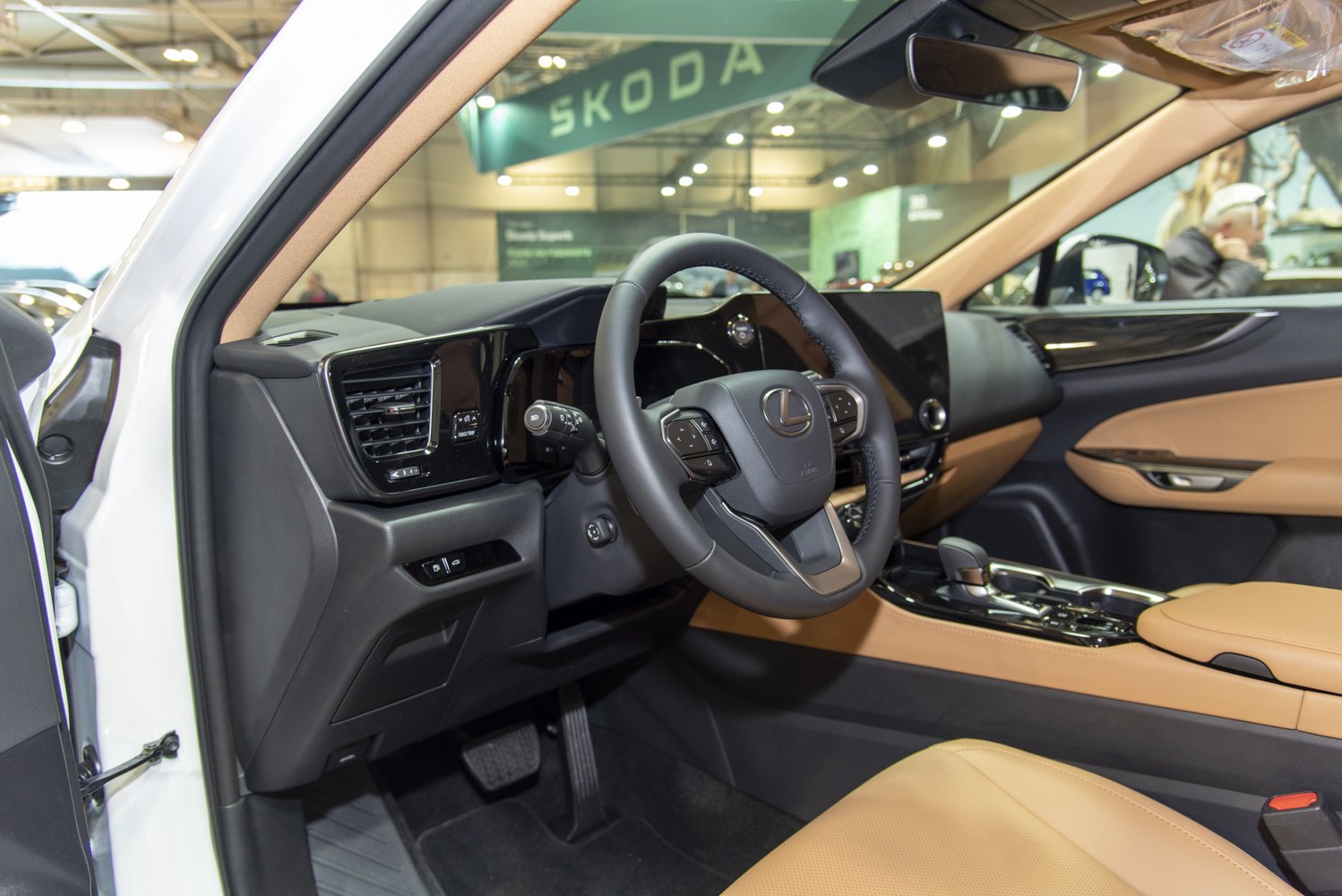 Steering wheel and dashboard with tan leather seats in luxury SUV interior