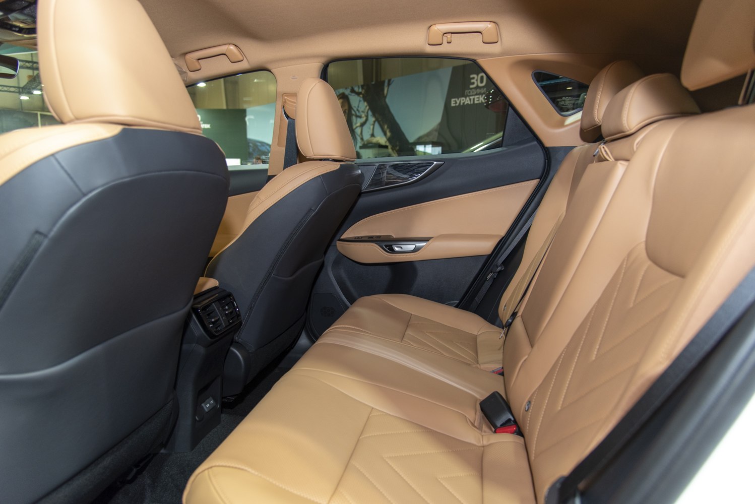 Premium tan leather rear seats with detailed stitching and modern door panel