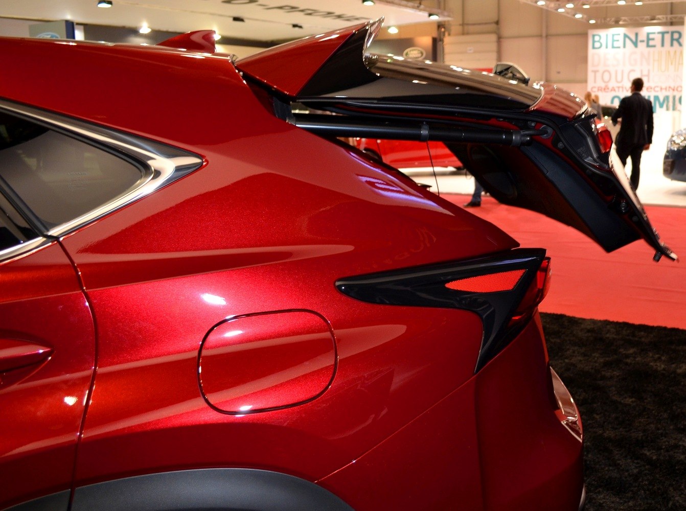Open rear tailgate and rear light design on red vehicle.
