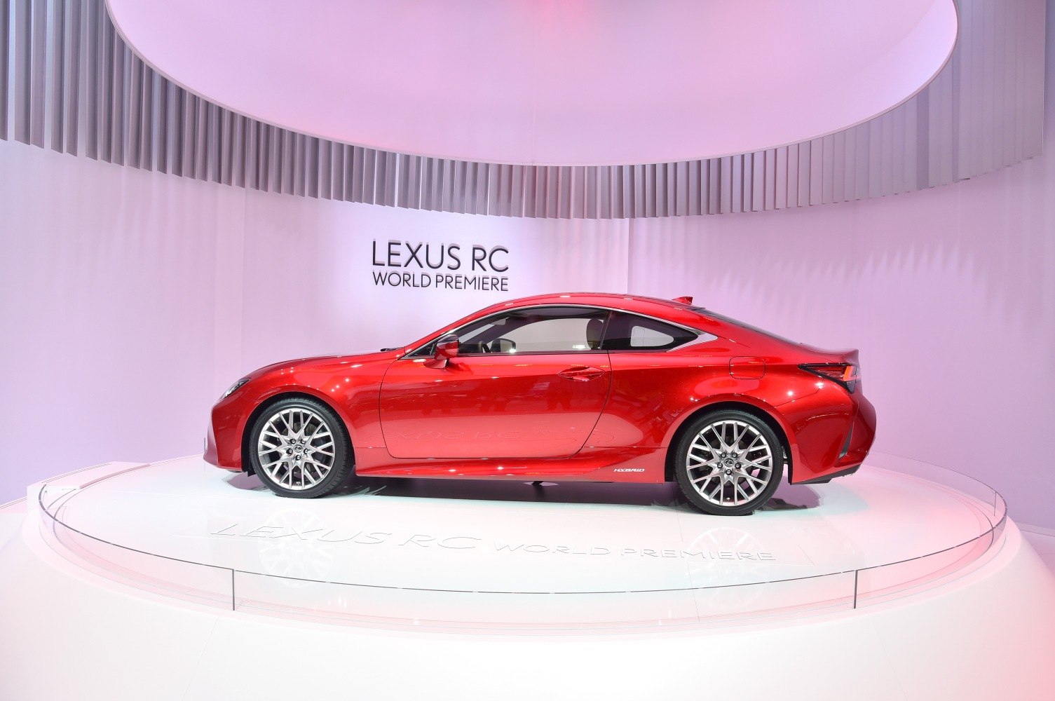 Red coupe car side profile with sporty alloy wheels and sleek roofline