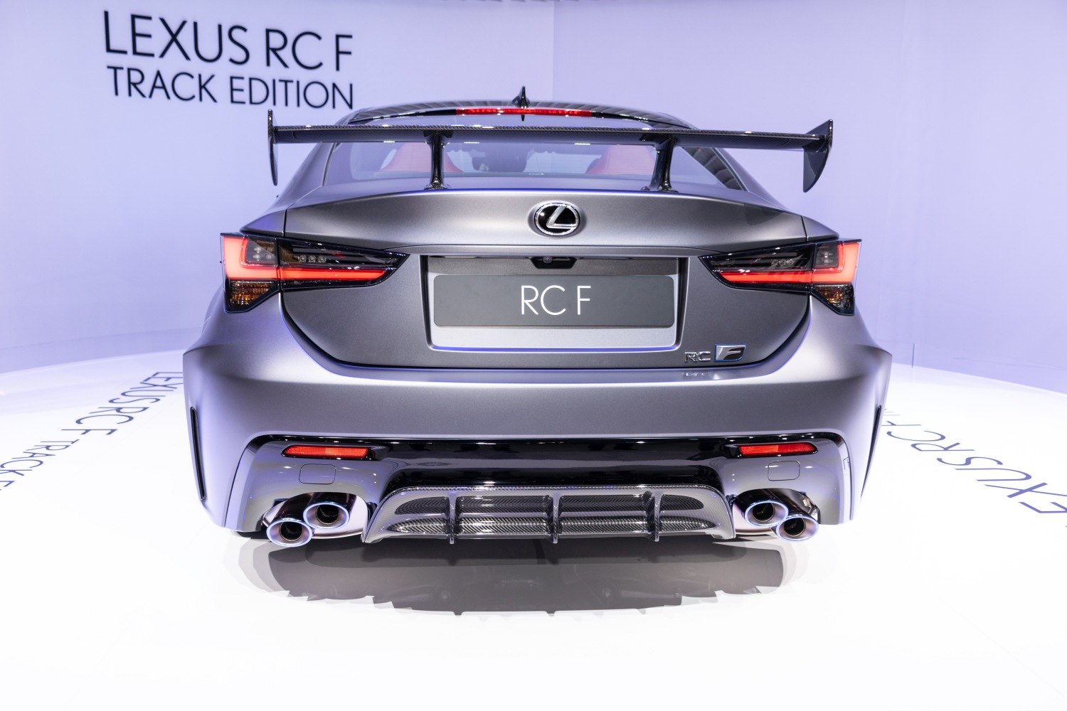 Rear view with carbon fiber rear wing, quad exhaust tips, aerodynamic diffuser