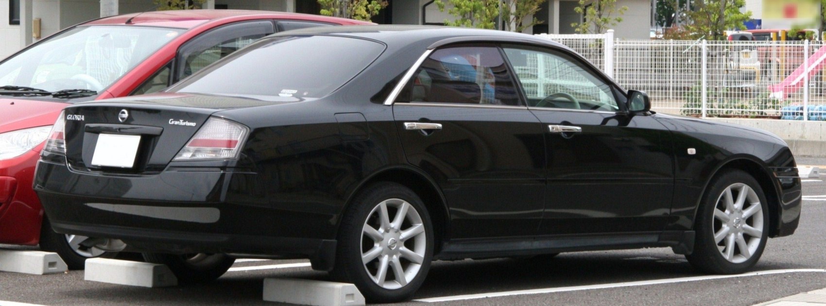 Rear and side view of a black luxury sedan with alloy wheels