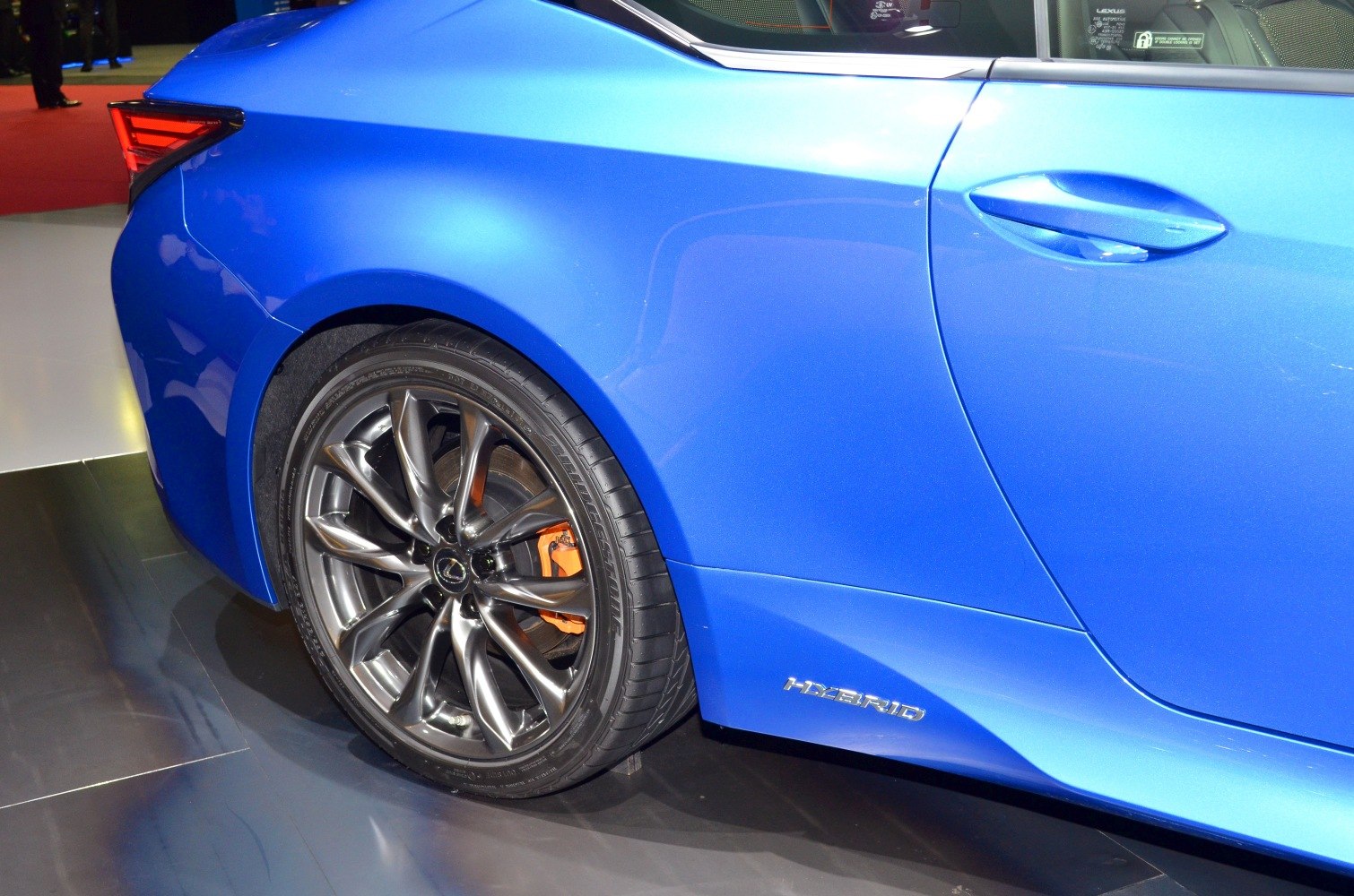 Rear wheel, orange brake caliper, side door with hybrid badge