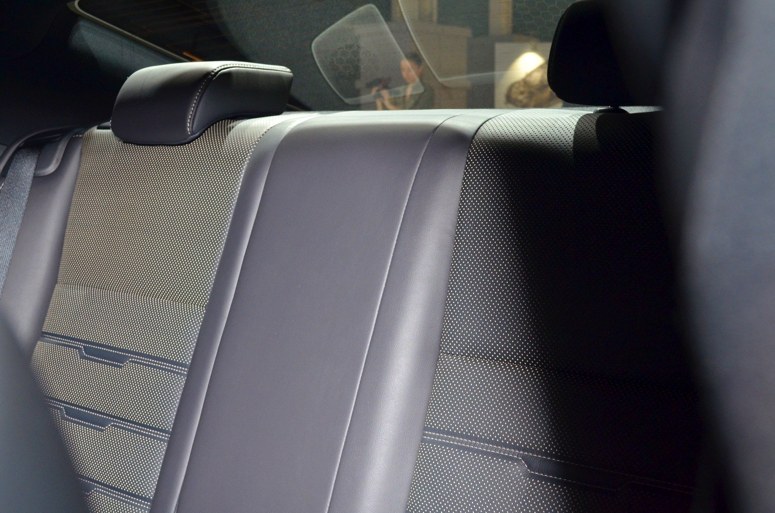 Rear leather seats upholstery with stitching and texture.