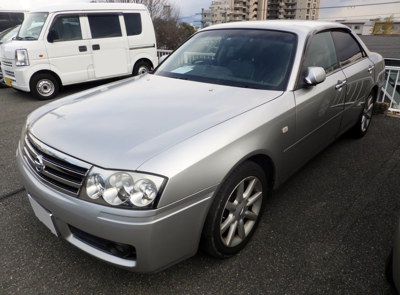 Silver mid-size sedan with quad round headlights and alloy wheels