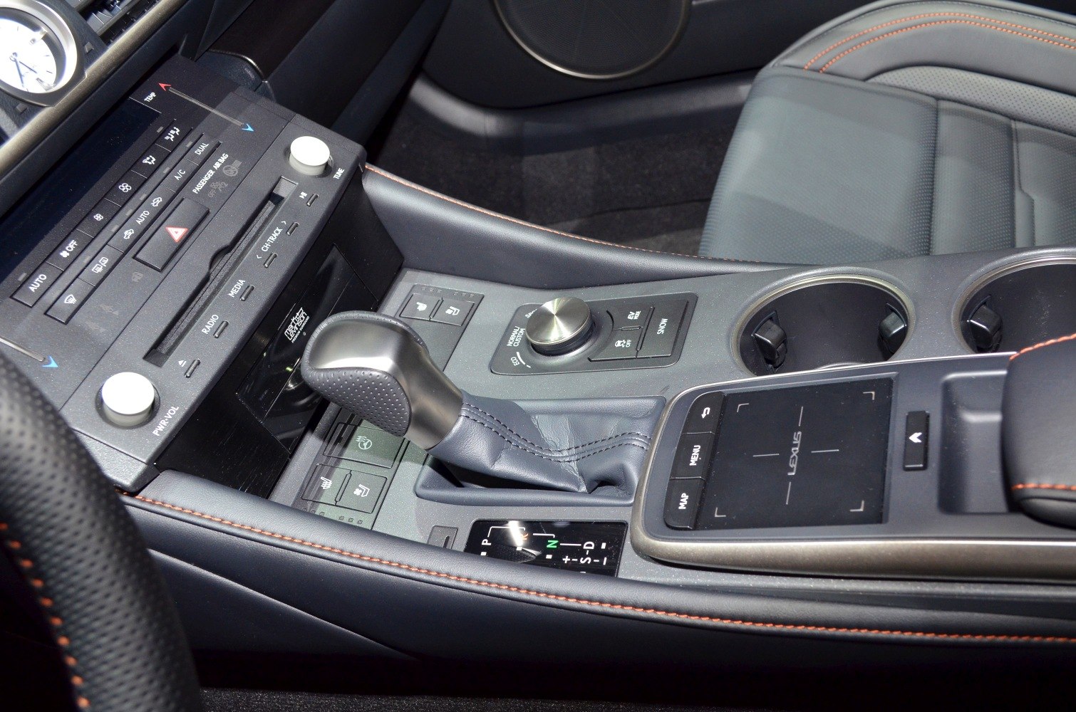 Center console with gear shifter, control knob, multimedia buttons, and leather upholstery.