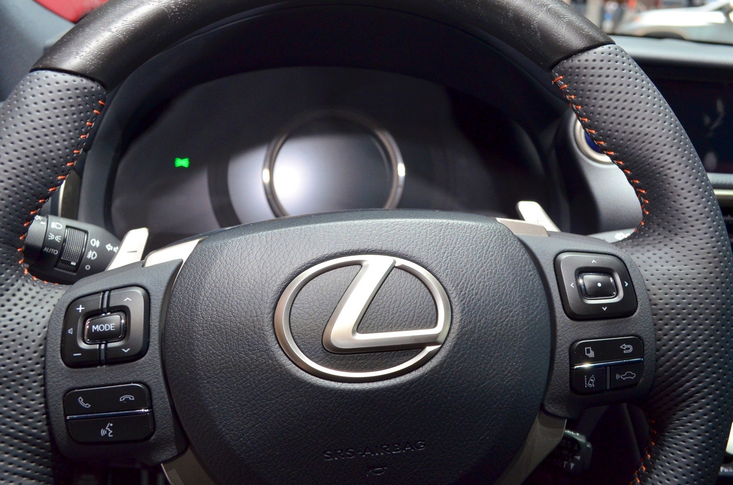Close-up of a steering wheel with control buttons and detailed leather stitching