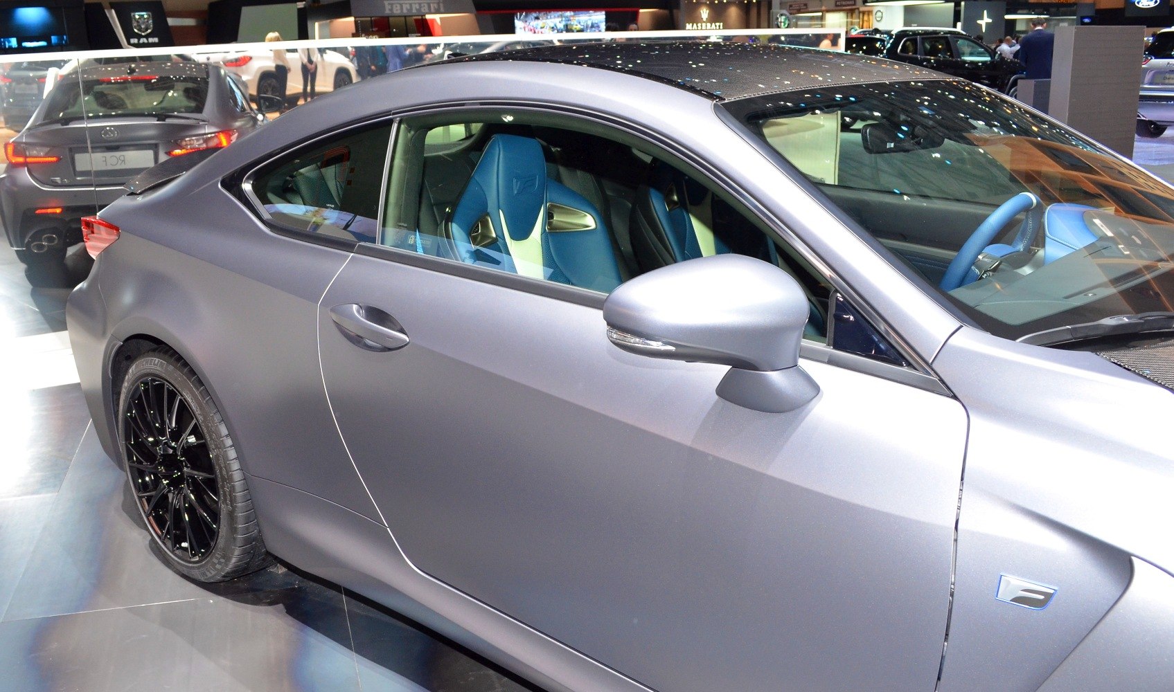 Side profile of matte grey coupe with blue sport seats and black rims