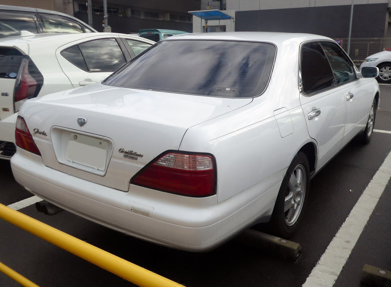 Rear view of a white sedan with distinct tail lights and smooth body lines.
