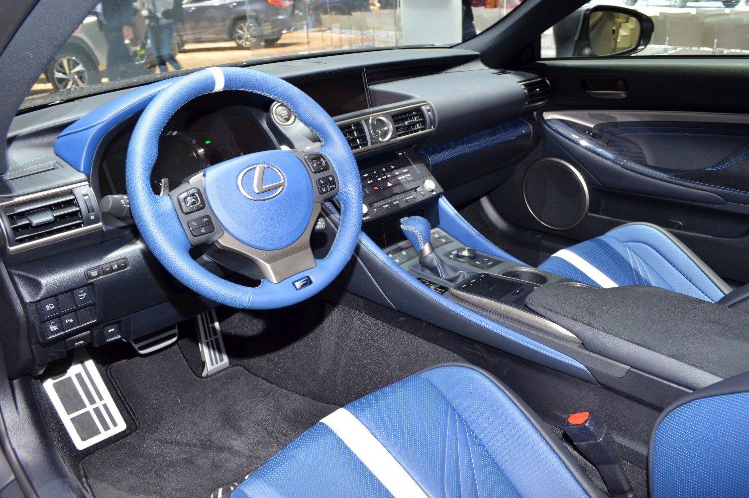 Blue leather steering wheel and seats with dashboard and modern controls.
