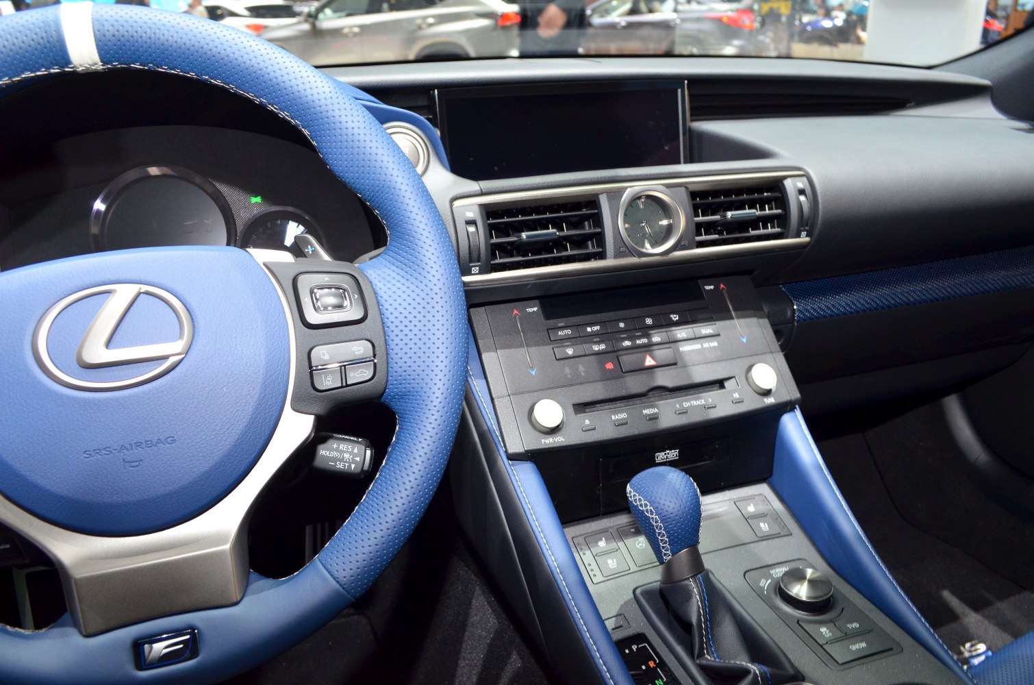 Blue leather steering wheel, analog clock, media controls and gear shifter