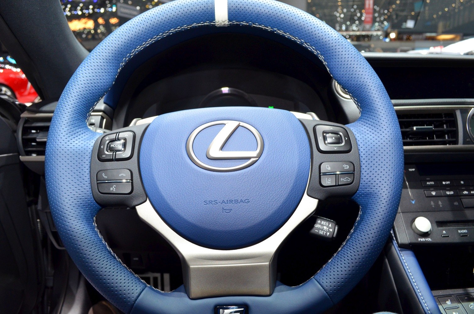 Blue perforated leather steering wheel with multi-function buttons and logo