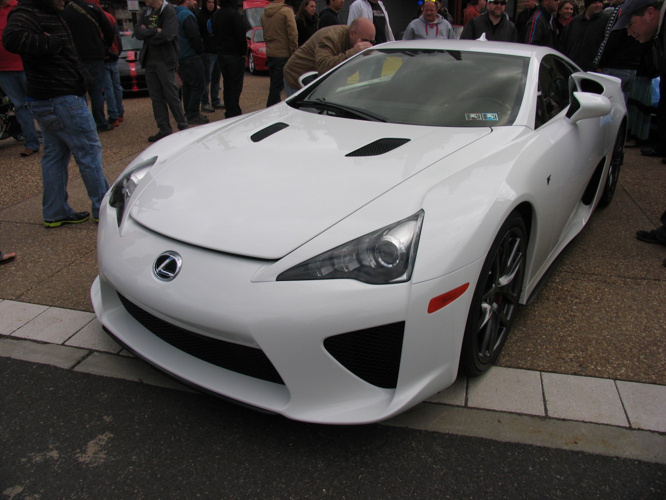 Close-up of sporty car hood vents and sleek, angular headlights.