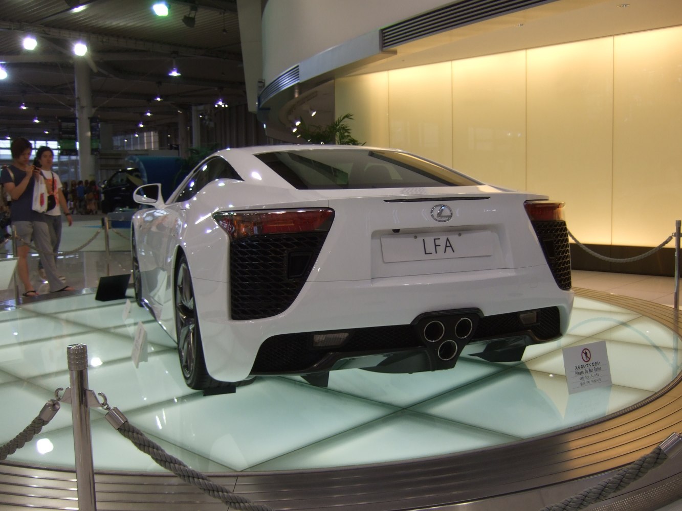Rear view of sports car featuring triple exhaust and aerodynamic elements