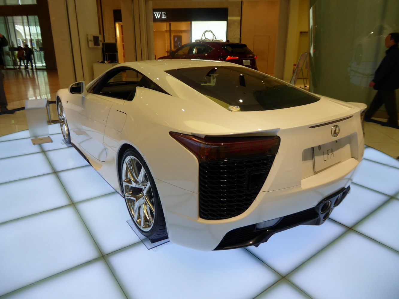 White supercar with aerodynamic rear design and distinct taillights.